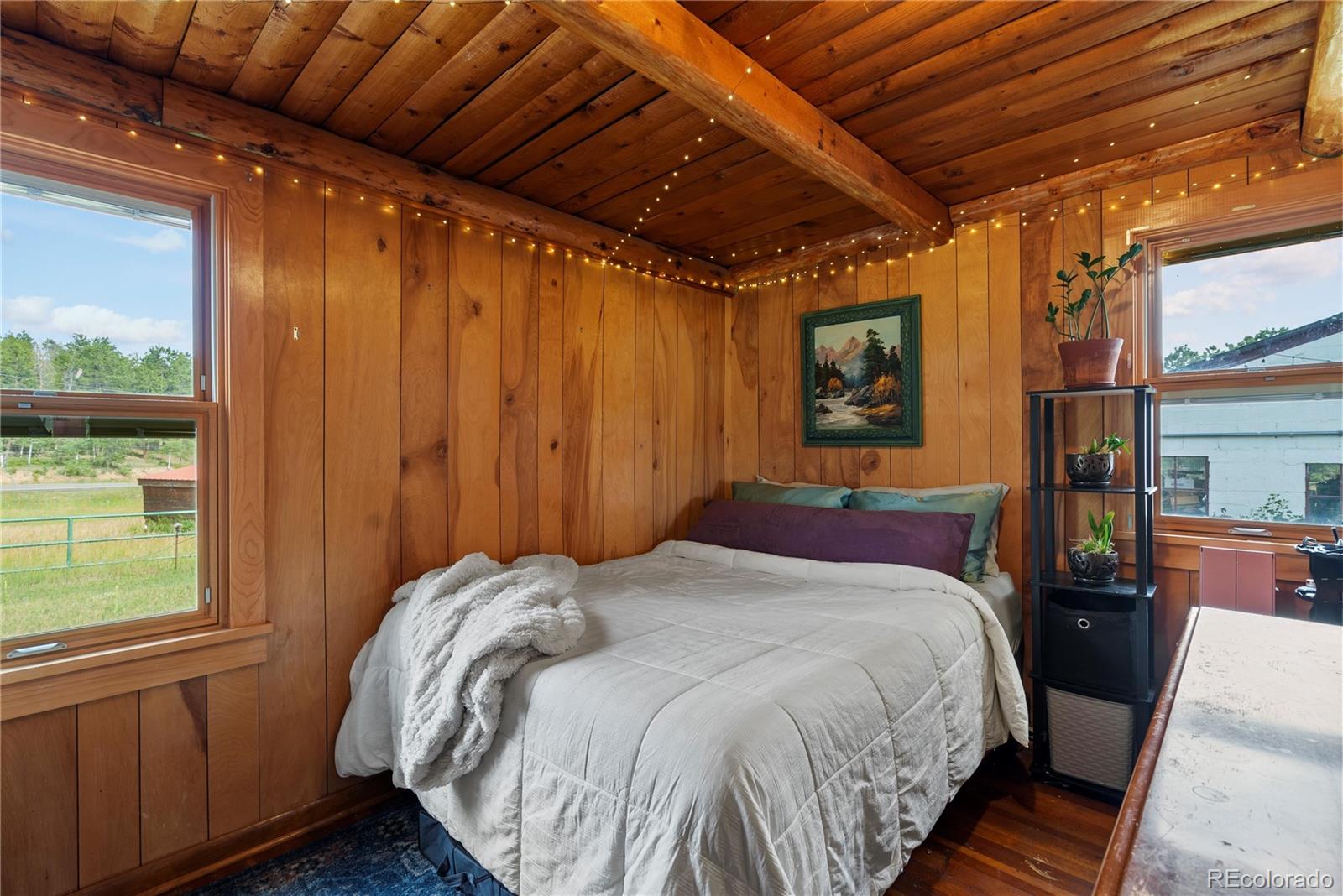 21852 Pleasant Park Road Conifer, CO 80433 - Photo 21 of 47 a bedroom with a bed next to a window