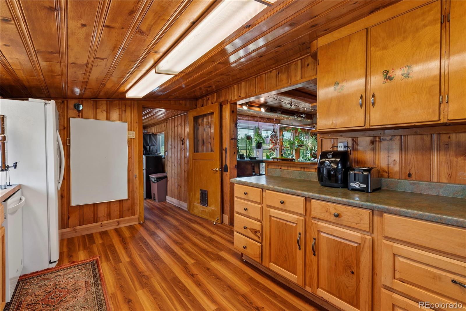 21852 Pleasant Park Road Conifer, CO 80433 - Photo 26 of 47 a kitchen with wooden cabinets and center island