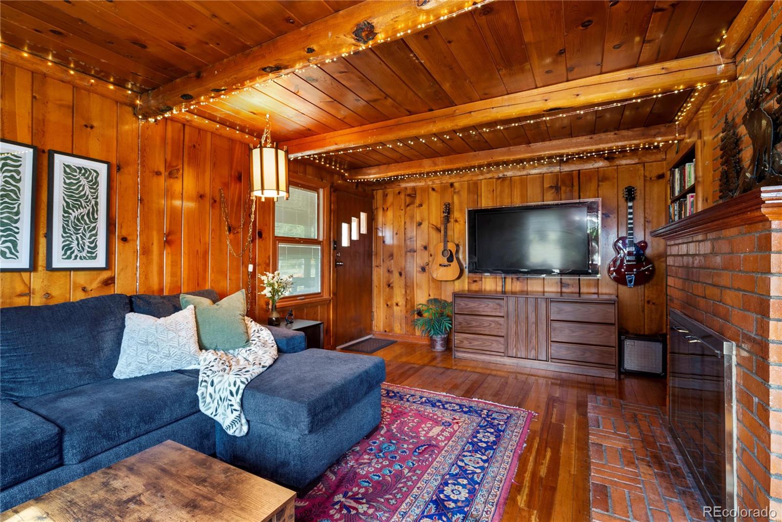 21852 Pleasant Park Road Conifer, CO 80433 - Photo 10 of 47 a living room with furniture and a flat screen tv