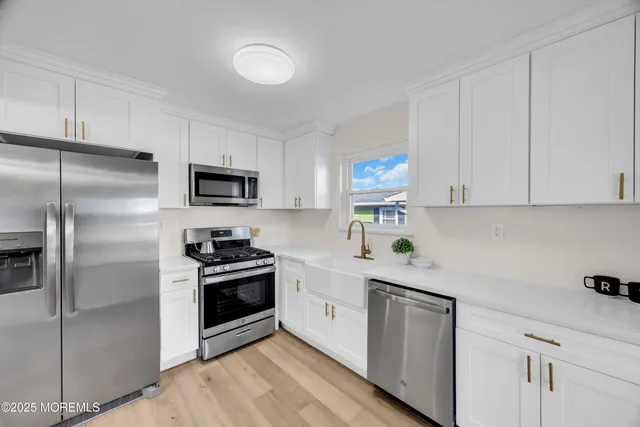 a kitchen with a sink cabinets and wooden floor