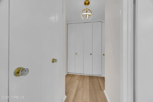 a view of a hallway with wooden floor and closet