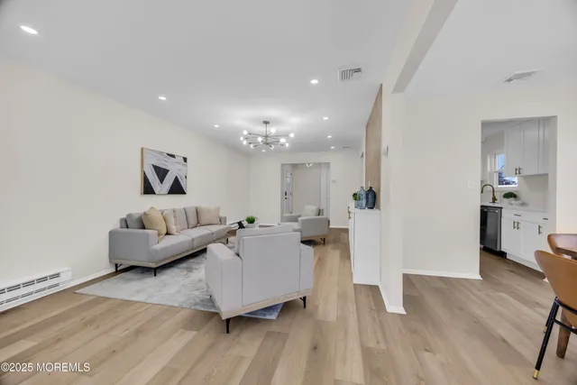 a dining room with furniture a chandelier and wooden floor