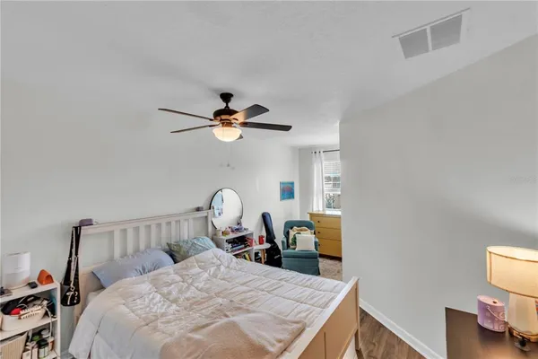 a bedroom with a bed a chandelier and dresser