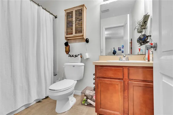 a bathroom with a sink a toilet and shower curtain