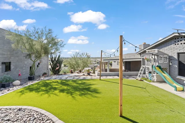 a view of a house with backyard and sitting area