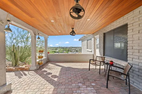 a view of a patio with dining table and chairs under an umbrella