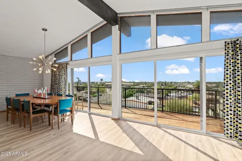 a view of a porch with chairs and floor to ceiling window
