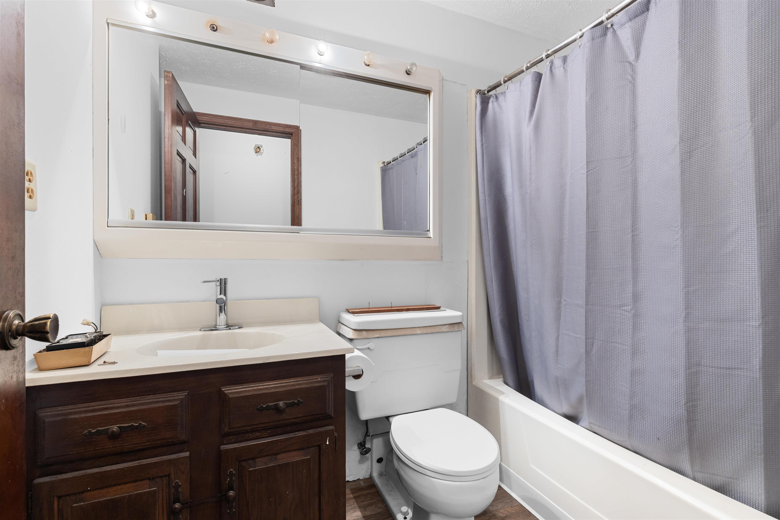 11754 Wange Road Capron, IL 61012 - Photo 12 of 19 a bathroom with a sink a toilet a mirror and shower curtain