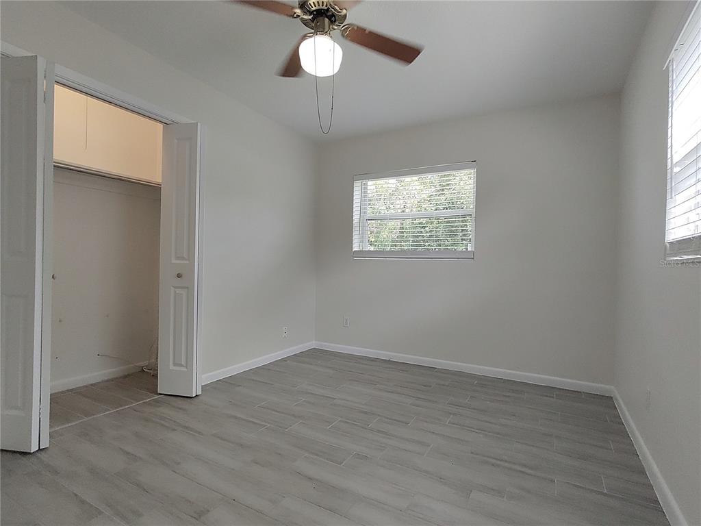516 Ellsworth Street Altamonte Springs, FL 32701 - Photo 20 of 30 an empty room with wooden floor chandelier fan and windows