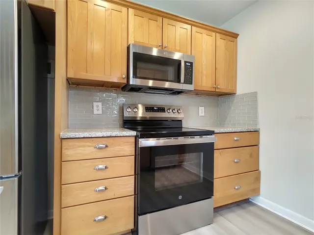 a kitchen with stainless steel appliances granite countertop white cabinets sink and a granite counter top