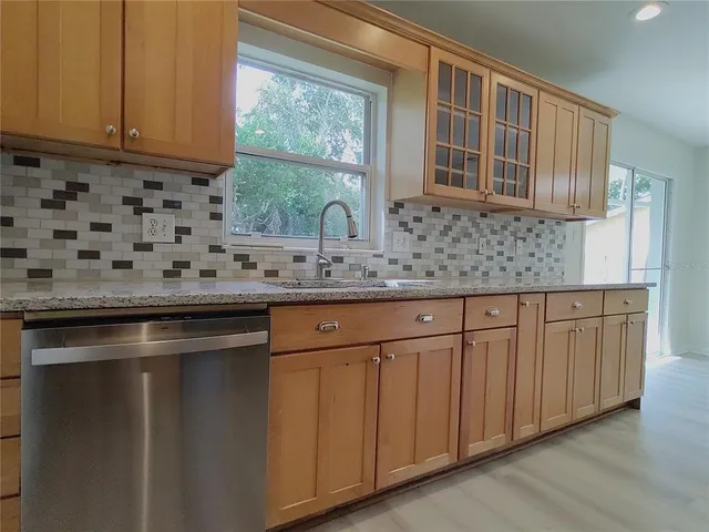 a kitchen with stainless steel appliances granite countertop a sink a stove and a microwave