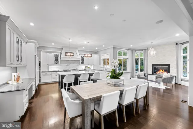 a large kitchen with dining table chairs chandelier and living room view