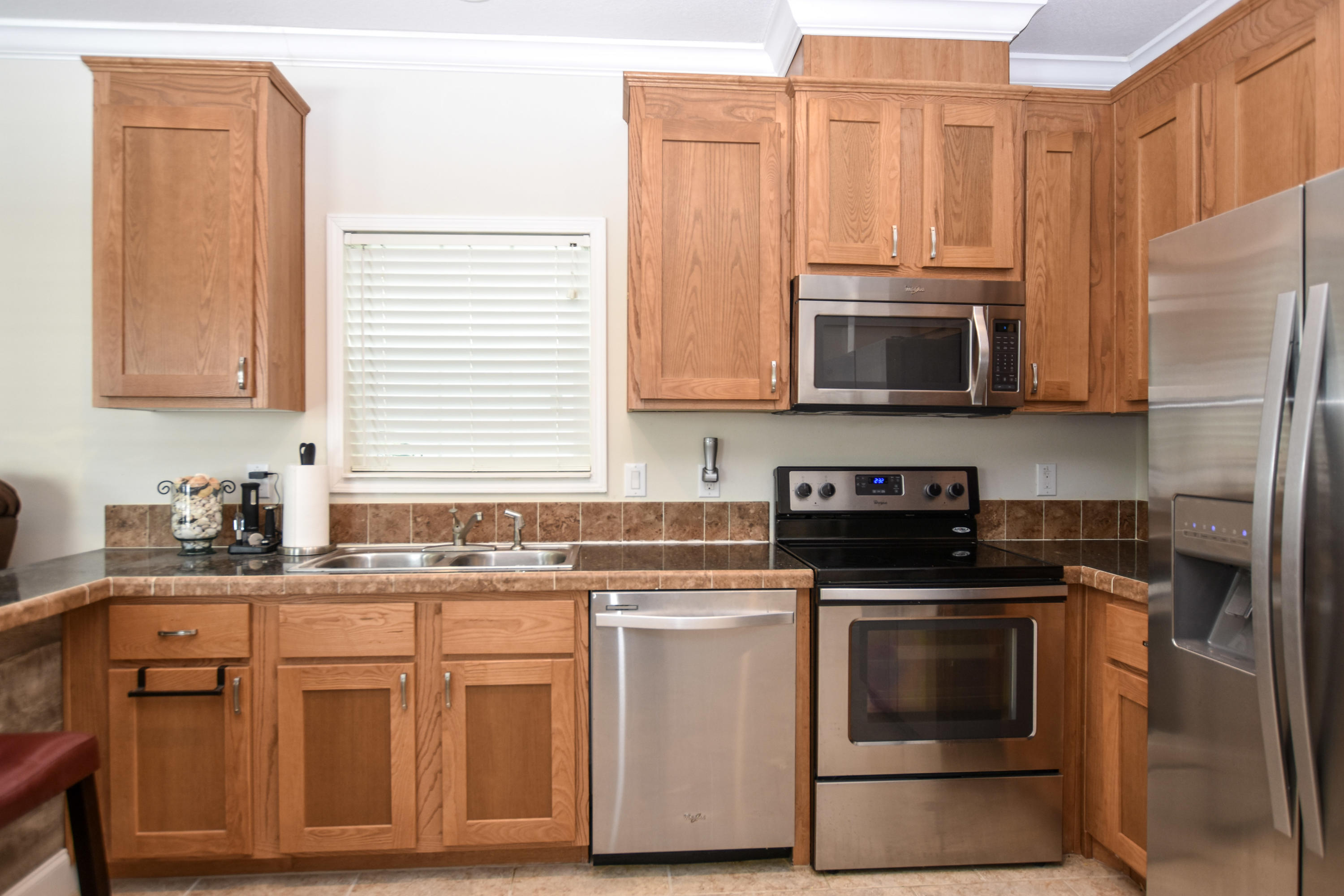 37 Palm Drive Key West, FL 33040 - Photo 6 of 24 a kitchen with stainless steel appliances granite countertop a stove a sink dishwasher and a microwave