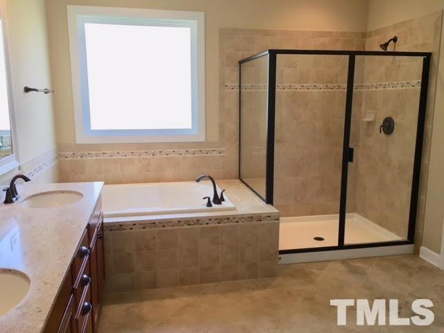 8505 Stonechase Drive Raleigh, NC 27613 - Photo 15 of 24 a bathroom with a tub a sink and a mirror