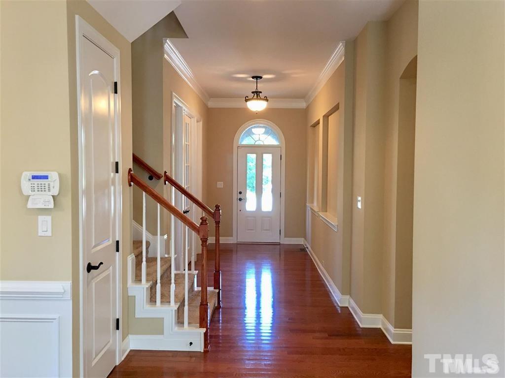 8505 Stonechase Drive Raleigh, NC 27613 - Photo 3 of 24 a view of a hallway with wooden floor and staircase