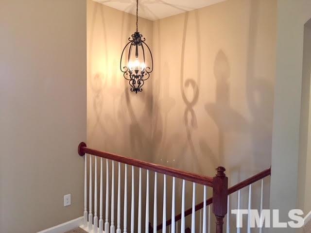 8505 Stonechase Drive Raleigh, NC 27613 - Photo 21 of 24 a view of a hallway with a chandelier