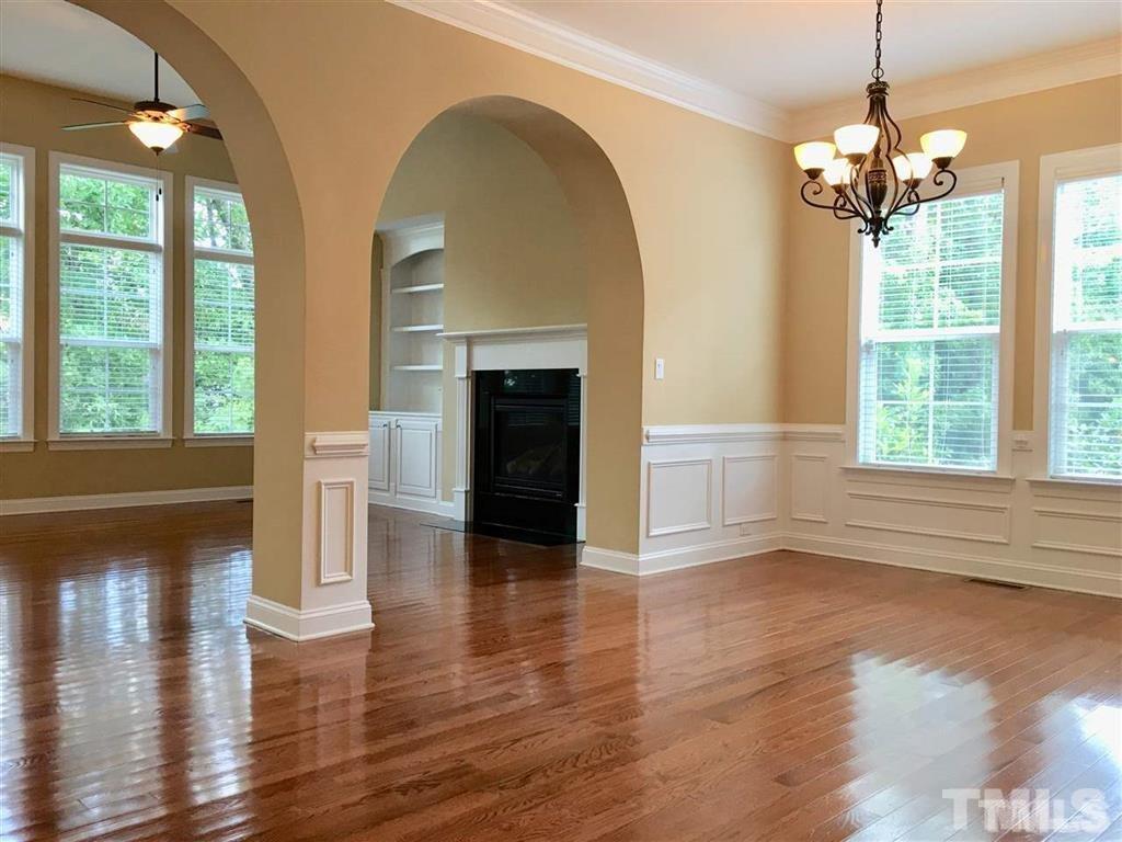 8505 Stonechase Drive Raleigh, NC 27613 - Photo 4 of 24 a view of an empty room with wooden floor fireplace and a window