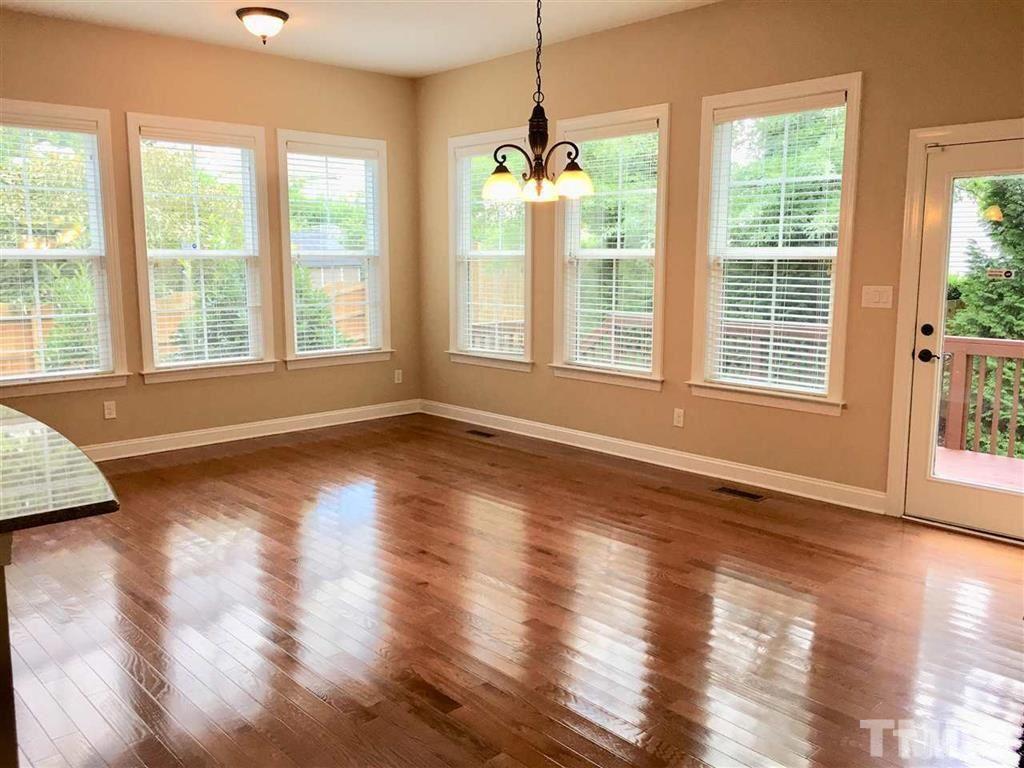 8505 Stonechase Drive Raleigh, NC 27613 - Photo 6 of 24 a view of an empty room with wooden floor and a window