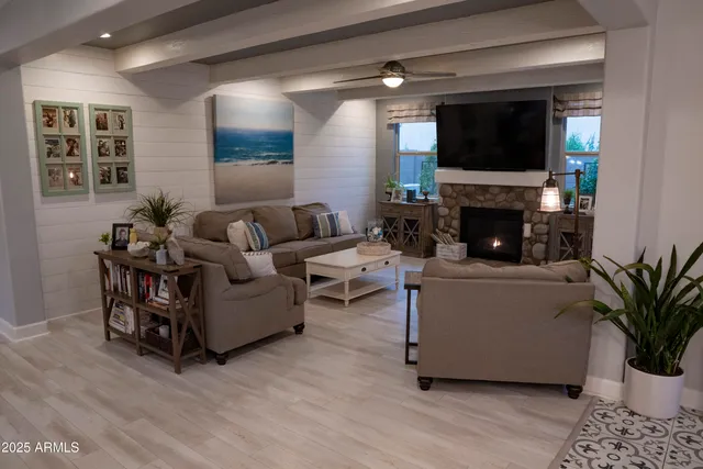 a living room with furniture a flat screen tv and a fireplace
