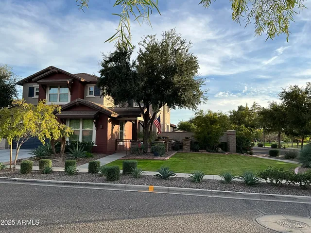 a front view of a house with a yard and potted plants
