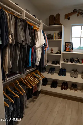 a view of walk in closet with clothes and shoes