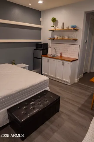 a bedroom with a chair and a flat screen tv
