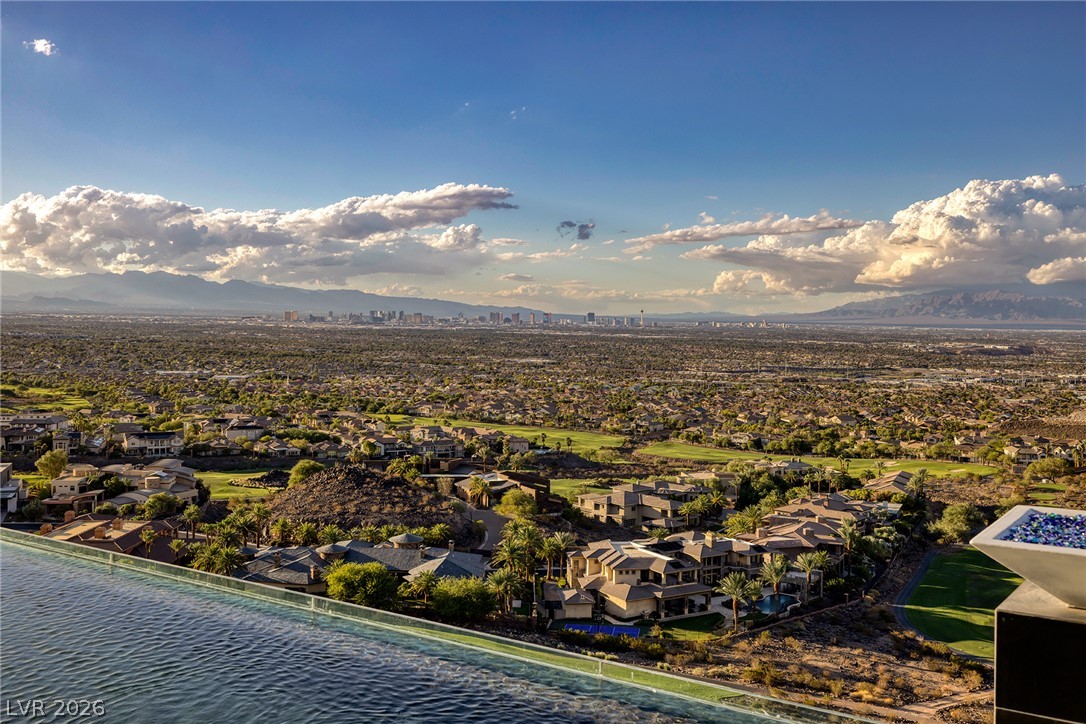 611 Cityview Ridge Drive Henderson, NV 89012 - Photo 54 of 66 A glass-edge infinity pool overlooks a sprawling golf course community with a distant city skyline view.