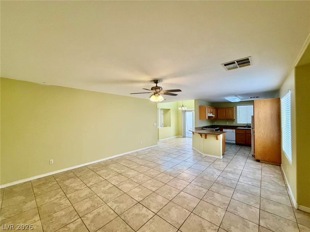 7326 Dicentra Road Las Vegas, NV 89113 - Photo 17 of 18 An open floorplan seamlessly connects the tiled living space with the kitchen area.