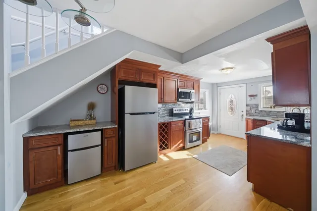 a kitchen with stainless steel appliances granite countertop a refrigerator a stove and a sink
