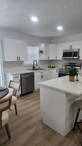 an empty room with wooden floor and a window