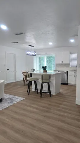 a view of a house with a yard potted plants and large tree