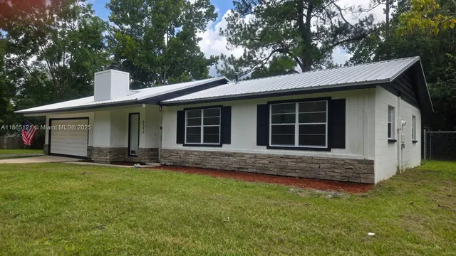 a front view of a house with a garden