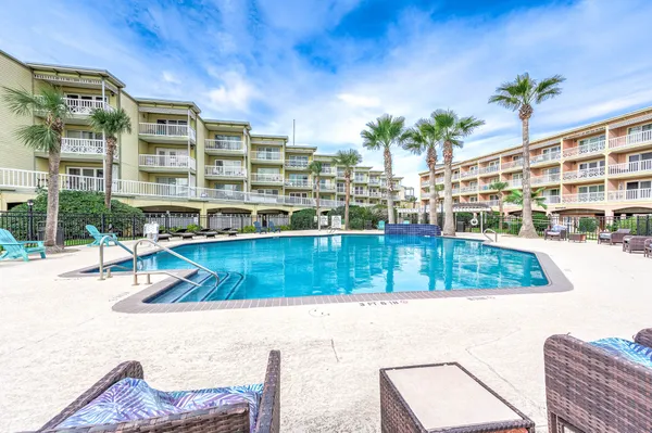 a view of swimming pool with outdoor seating and plants
