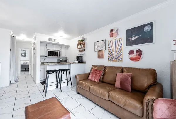 a living room with furniture kitchen view and a window