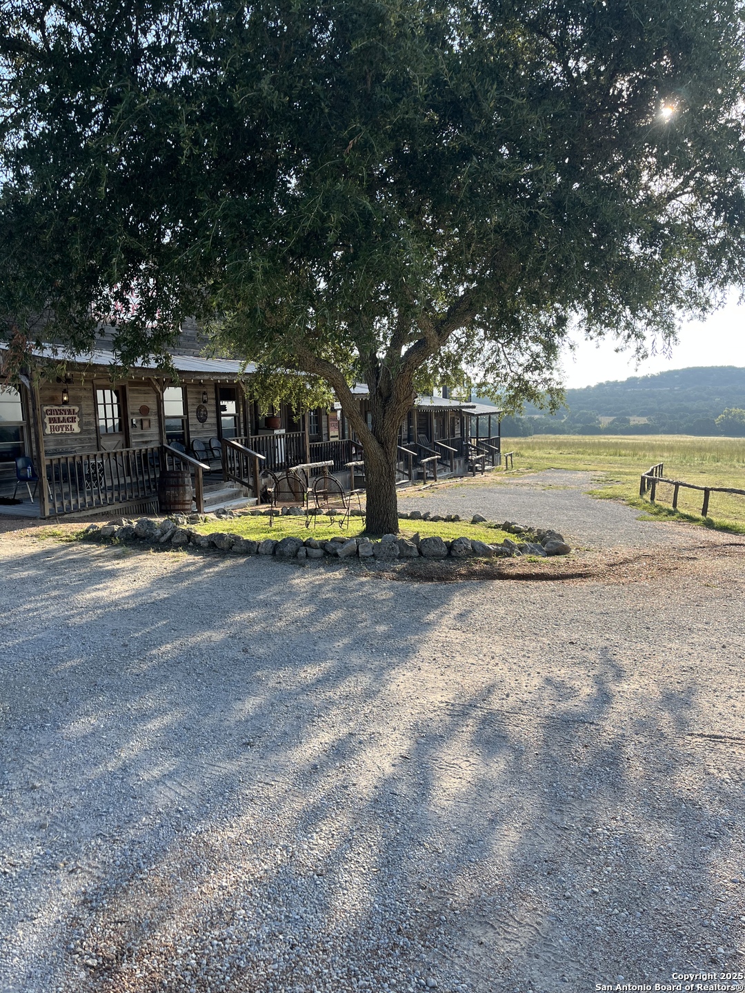 a view of swimming pool with lawn chairs and large trees