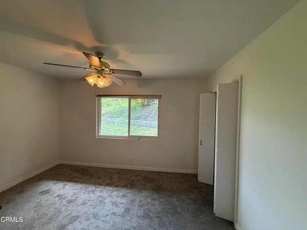 a view of a livingroom with a fireplace a chandelier and windows