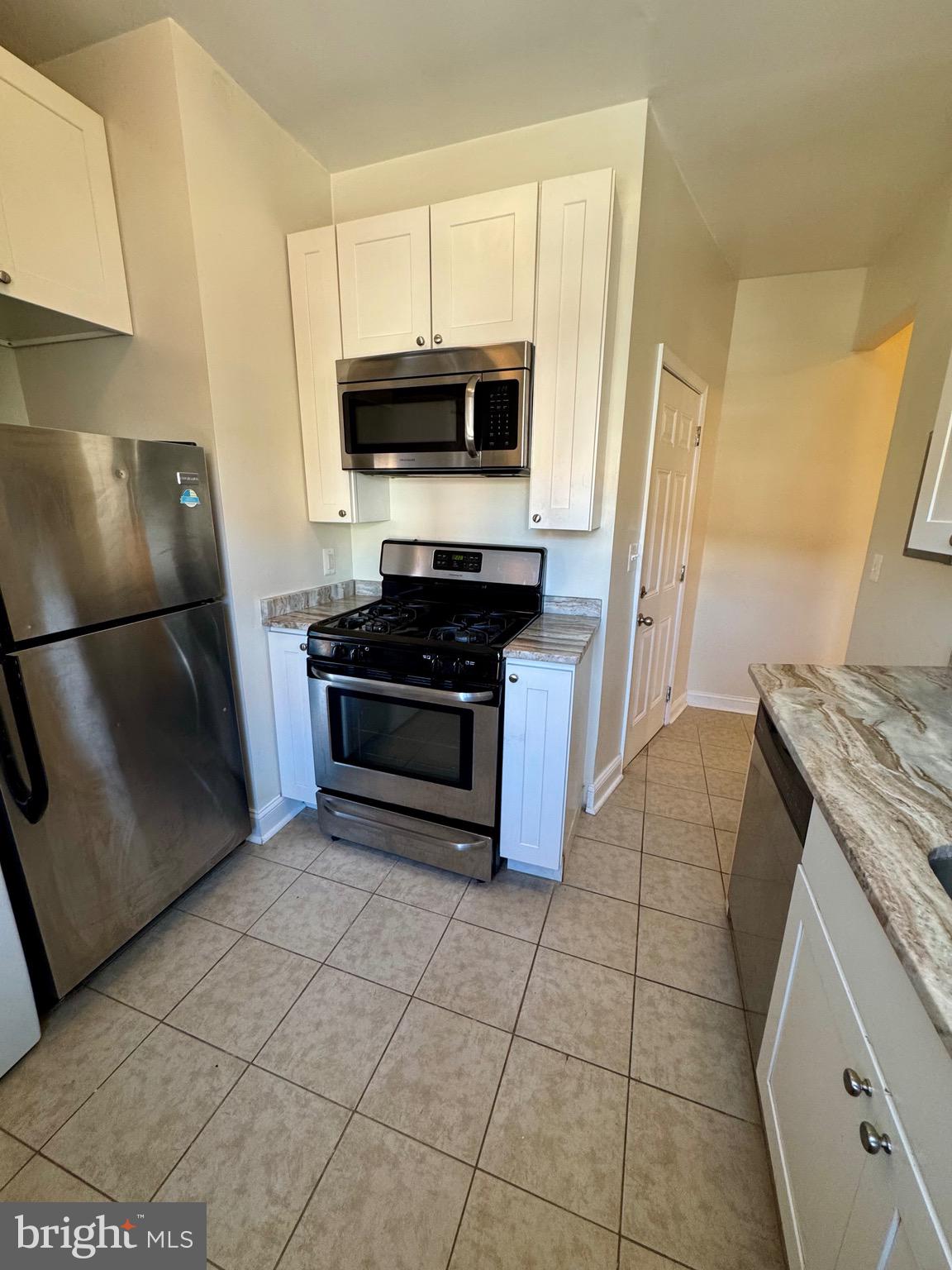 445 East Fort Avenue, Unit A Baltimore, MD 21230 - Photo 3 of 18 a kitchen with stainless steel appliances granite countertop a stove a refrigerator and a microwave