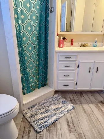 a view of a bedroom with baby crib and wooden floor
