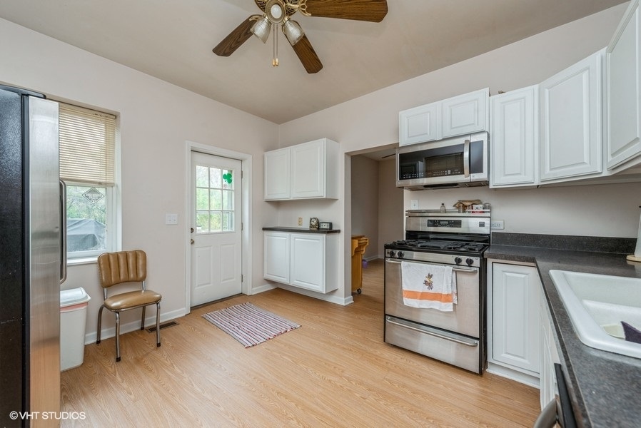 14-n043 Reinking Road Hampshire, IL 60140 - Photo 5 of 12 a kitchen with stainless steel appliances a stove a sink and white cabinets