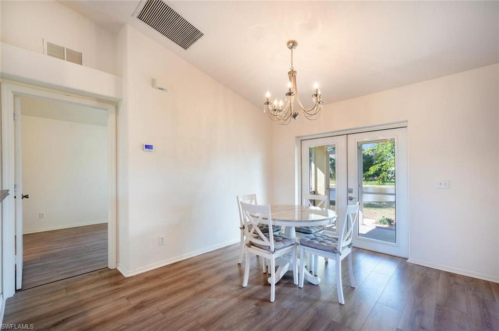 135 Blue Ridge Drive, Unit 35 Naples, FL 34112 - Photo 8 of 23 Dining space with visible vents, wood finished floors, french doors, and a chandelier