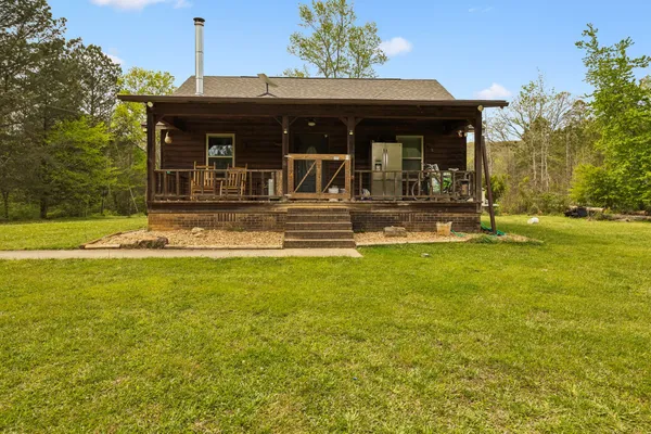 a view of a house with a yard and sitting area