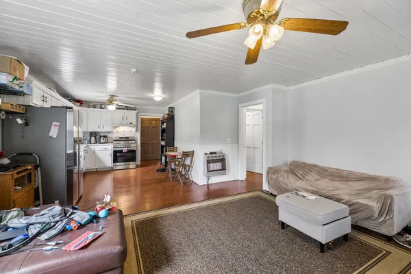 a kitchen with kitchen island wooden floor and refrigerator