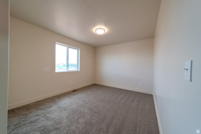 130 Pole Line Road, Unit 2 Roosevelt, UT 84066 - Photo 23 of 33 Spacious room featuring neutral carpeting, light-toned walls, and a large window
