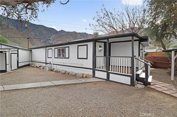 a view of a house with a yard and fence