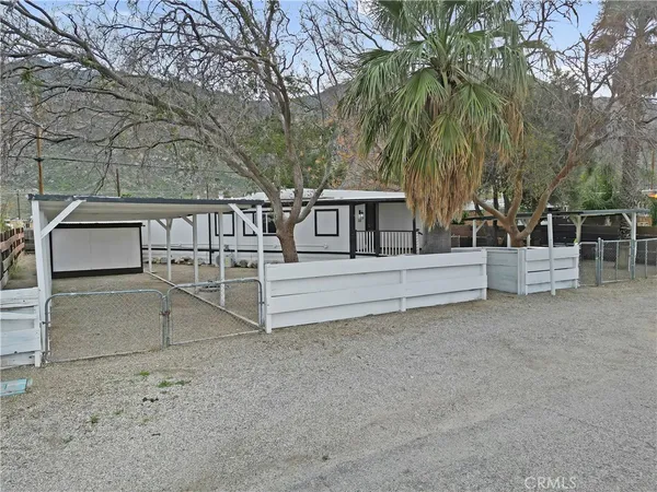 a view of a house with backyard and trees