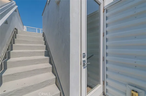 a view of staircase with white walls and white door