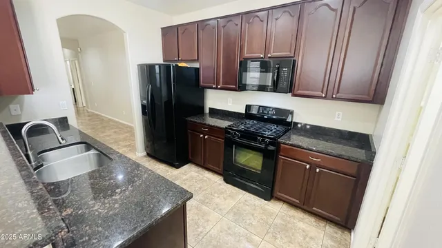 a kitchen with granite countertop wooden cabinets and stainless steel appliances