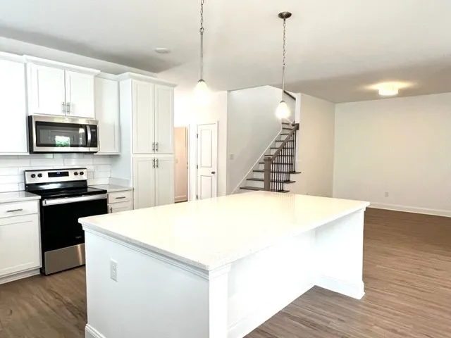 a view of kitchen with wooden floor electronic appliances and window