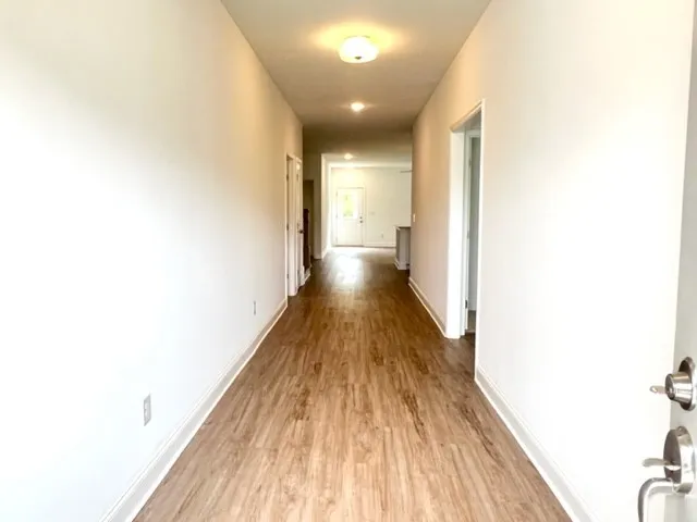 a view of a hallway with wooden floor