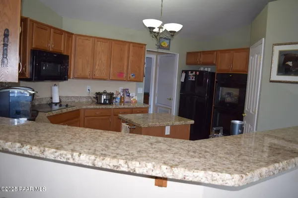 a kitchen with stainless steel appliances granite countertop a sink a stove and a refrigerator